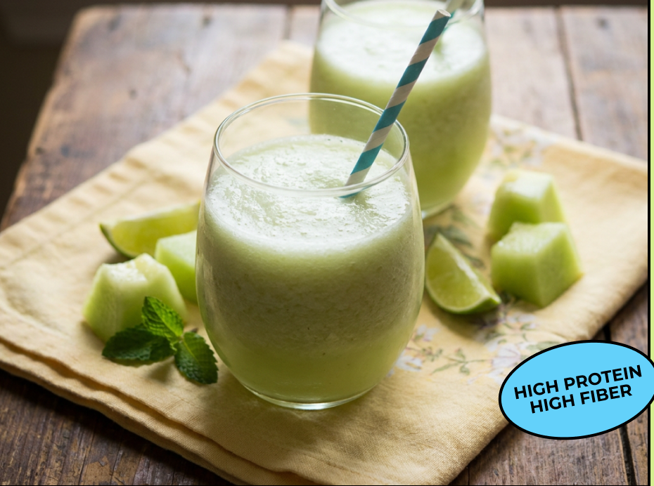 A glass of creamy honeydew lime shake with melon chunks, lime and mint